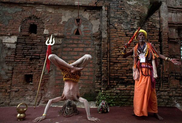 یک مرد مقدس هندی سادو یا هندو، در سمت چپ، در معبد کاماخیا در طول جشنواره آمبوباچی، در گائوهاتی هند، یوگا انجام می دهد. - اسپوتنیک افغانستان  