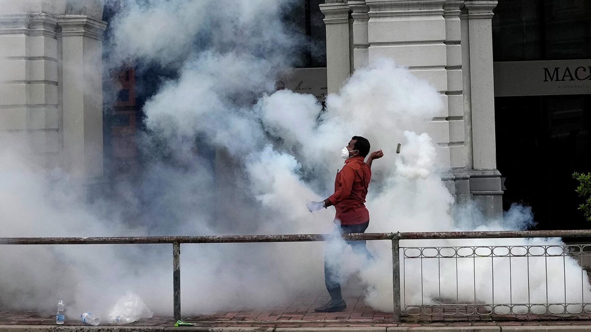Протестующий бросает баллончик со слезоточивым газом во время столкновения с полицией в Коломбо (9 июля 2022). Шри-Ланка - اسپوتنیک افغانستان  , 1920, 10.07.2022