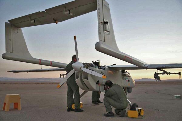 تصویر منتشر شده توسط ارتش ایران در 24 اگست سال 2022، تکنسین‌ها را نشان می‌دهد که یک طیارۀ بدون سرنشین نظامی (پهپاد) را در یک فرودگاه طی یک رزمایش پهپادی دو روزه در مکانی نامعلوم در ایران بررسی می‌کنند. - اسپوتنیک افغانستان  