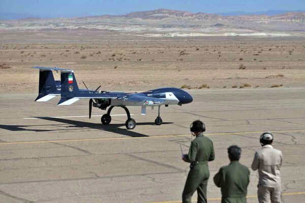 تصویر منتشر شده توسط ارتش ایران در 24 اگست سال 2022، تکنسین‌ها را نشان می‌دهد که یک طیارۀ بدون سرنشین نظامی (پهپاد) را در یک فرودگاه طی یک رزمایش پهپادی دو روزه در مکانی نامعلوم در ایران بررسی می‌کنند. - اسپوتنیک افغانستان  