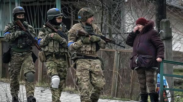 Женщина смотрит на украинских военнослужащих в Буче, Украина - اسپوتنیک افغانستان  