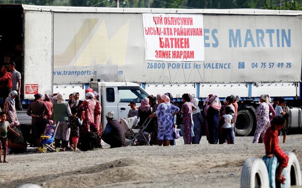 مهاجرین برای کمک های بشردوستانه در سرک روستای بوز آدیر در قرغیزستان صف می کشند. - اسپوتنیک افغانستان  
