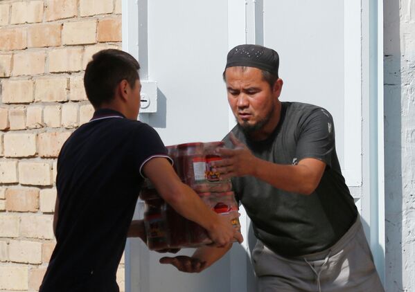 تخلیه مواد خوراکه کمک های بشردوستانه به پناهندگان در منطقه بوز ادیر. - اسپوتنیک افغانستان  