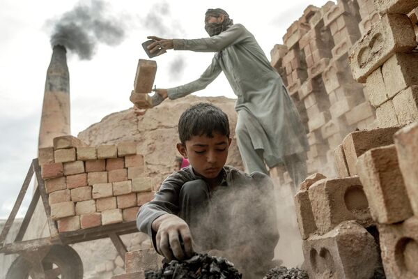 طفل 8 ساله برای بدست آوردن پول در یک کوره خشت درحال انجام دادن کار است.  - اسپوتنیک افغانستان  