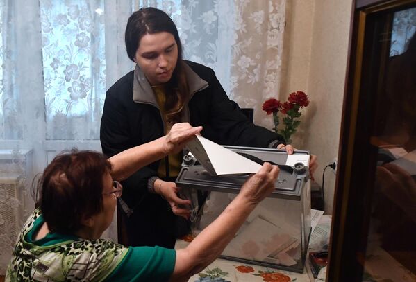 شرکت یک زن در همه پرسی در مورد پیوستن جمهوری خلق دونتسک به فدراسیون روسیه رای می دهد. - اسپوتنیک افغانستان  