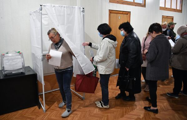 مردم طی همه پرسی در مورد الحاق منطقهZaporozhye به روسیه در یک مرکز رای گیری در شرکتMelitopol رای می دهند. - اسپوتنیک افغانستان  