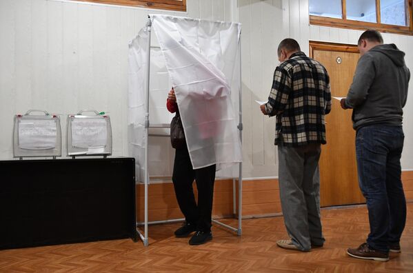 مردم در یک همه پرسی در مورد الحاق منطقه Zaporozhye به روسیه در یک مرکز رای گیری در شرکت Melitopol رای می دهند. - اسپوتنیک افغانستان  