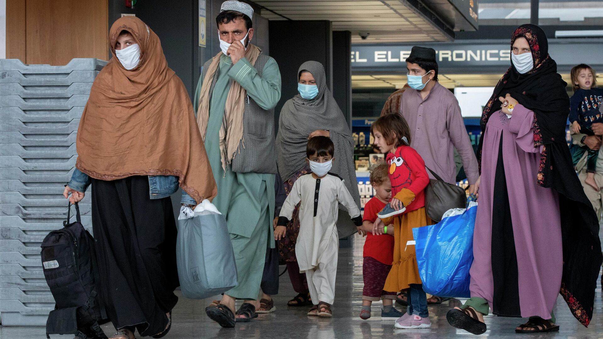 Families evacuated from Kabul, Afghanistan walk through the terminal to board a bus after they arrived at Washington Dulles International Airport, in Chantilly, Va., Sept. 1, 2021. - اسپوتنیک افغانستان  , 1920, 28.09.2022