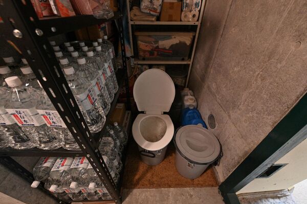 در این عکس یک توالت قابل حمل و بعضی از ضروریات روزانه مانند آب و غذا در این پناهگاه زیر زمینی را می بینید. - اسپوتنیک افغانستان  