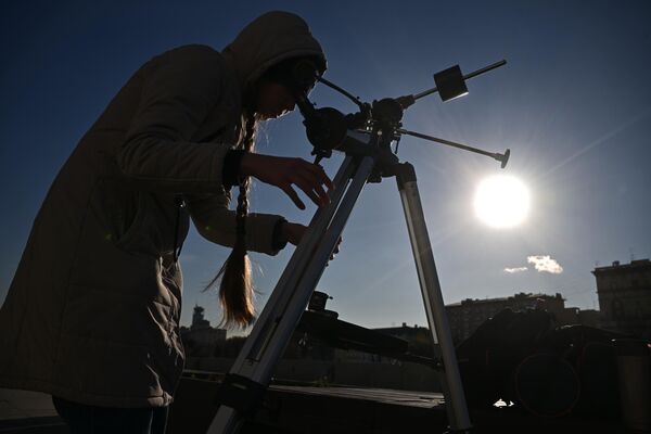 دختری از طریق تلسکوپ خورشید گرفتگی جزئی را در مسکو تماشا می کند. - اسپوتنیک افغانستان  