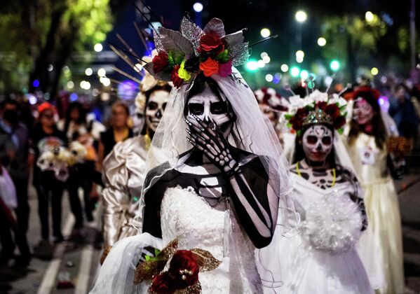 مردم در رژه کاتریناس، به نمایندگی از شخصیت لا کاترینا برای بزرگداشت روز مردگان، در مکزیکو سیتی، در 23 اکتوبر 2022 شرکت می کنند. (عکس از کلودیو کروز / خبرگزاری فرانسه) - اسپوتنیک افغانستان  