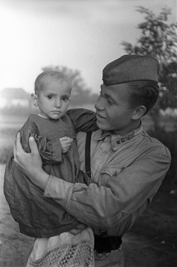جنگ بزرگ میهنی 1941-1945. جبهه قفقاز شمالی یک دخترک نجات یافته در آغوش یک افسر شوروی است. - اسپوتنیک افغانستان  
