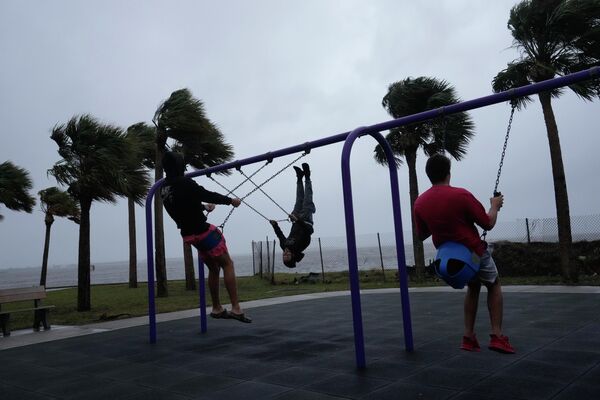 مردان در حال بازی (گاز خوردن) در جریان طوفان &quot;نیکول&quot; در کنار ساحل جنسن، فلوریدا، ایالات متحده امریکا. - اسپوتنیک افغانستان  