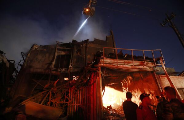 آتش نشانان در حال بررسی صحنه آتش سوزی در یکی از ساختمان ها در شهر بغداد. - اسپوتنیک افغانستان  