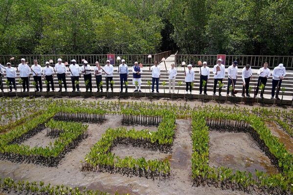 رهبران گروه 20 در حین یک رویداد درختکاری در جنگل حرا تامان هوتان رایا نگوراه رای، در حاشیه نشست سران گروه 20 در نوسا دوآ، در جزیره تفریحی بالی اندونزی در 16 نوامبر 2022، آنها بیل  های باغبانی خود را برای عکس دسته جمعی بالا می برند. - اسپوتنیک افغانستان  
