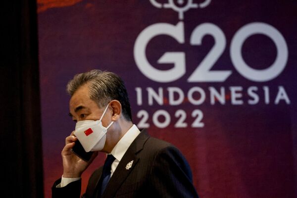 وانگ یی وزیر امور خارجه چین طی مراسم تحویل در اجلاس سران G20 در نوسا دعا، بالی، اندونزی، چهارشنبه 16 نوامبر 2022  در حال تماس تلفنی. - اسپوتنیک افغانستان  