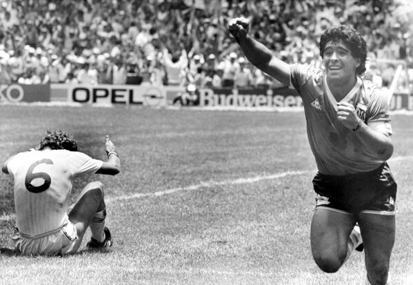 دیگو مارادونای آرژانتینی پس از اینکه دومین گل خود را در یک چهارم نهایی جام جهانی در مکزیکو سیتی مکزیک در 22 جون 1986 به ثمر رساند، در زمین فوتبال با خوشحالی می دود. تری بوچر از انگلیس روی زمین نشسته است. - اسپوتنیک افغانستان  