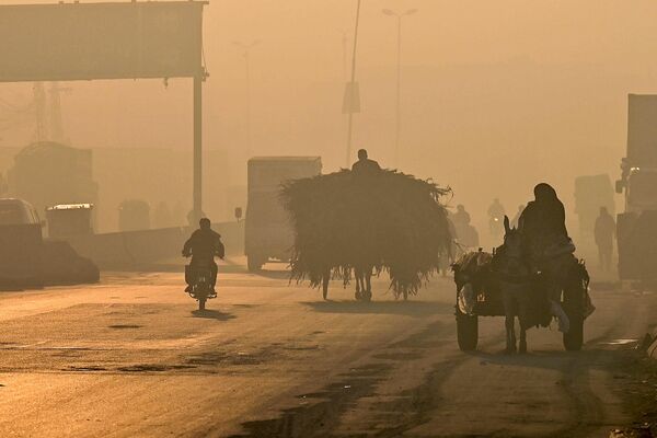 مسافران راه خود را در امتداد جاده در میان دود شدید در لاهور طی می کنند - اسپوتنیک افغانستان  