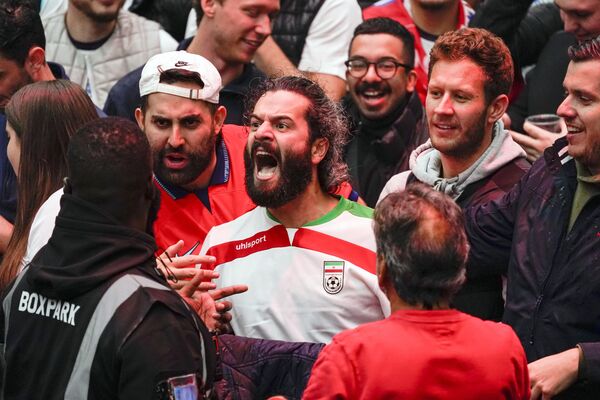 یک هوادار فوتبال ایران در جریان بازی گروه B فوتبال جام جهانی بین انگلیس و ایران در &quot;فن زون&quot; در لندن21 نوامبر 2022 - اسپوتنیک افغانستان  