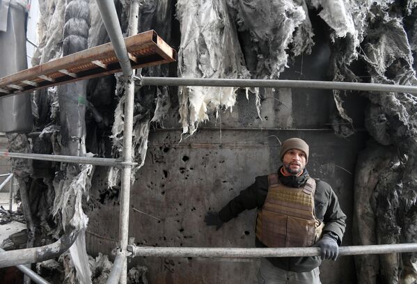 کارمند Rosenergoatom دیمیتری شوچنکو در یک مخزن آسیب دیده با آب مقطر برای اطمینان از عملکرد واحد چهارم نیروگاه هسته ای زاپروژیا پس از گلوله باران اخیر توسط نیروهای مسلح اوکراین. - اسپوتنیک افغانستان  