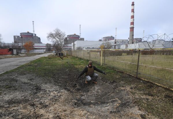 دیمیتری شوچنکو، کارمند Rosenergoatom در دهانه آتشفشانی ناشی از انفجار گلوله در قلمرو نیروگاه هسته ای زاپروژیا پس از گلوله باران اخیر توسط نیروهای مسلح اوکراین. - اسپوتنیک افغانستان  