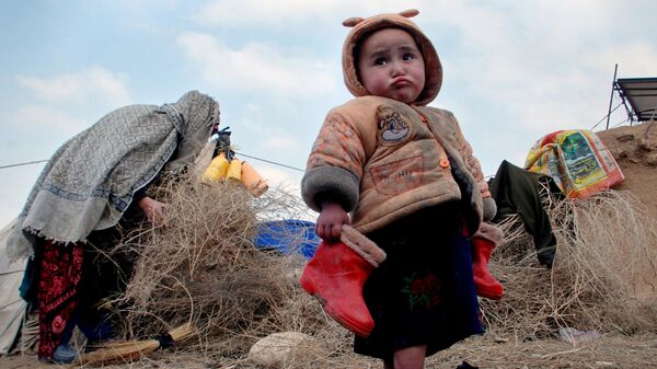 Афганский ребенок с сапожками в руках в лагере для внутренне перемещенных лиц на окраине Мазари-Шарифа, к северу от Кабула, Афганистан, 2014 год - اسپوتنیک افغانستان  