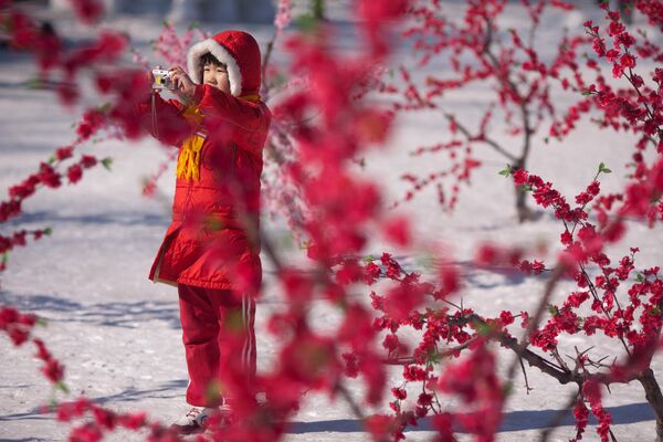 یک دختر کوچک در حالی بازی و عکس گیری در فضای زمستانی معبد لانگتان در پکن  24 جنواری 2012  - اسپوتنیک افغانستان  