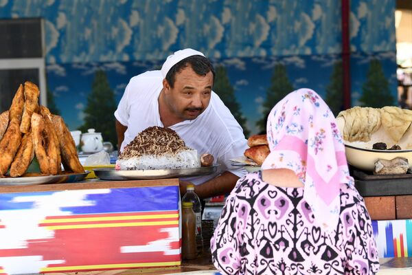 فروشنده با خانم در بازار تاشکند صحبت می نماید. - اسپوتنیک افغانستان  