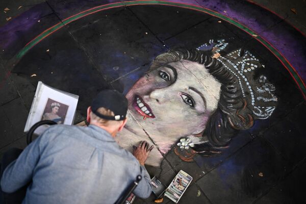 یک هنرمند پرتره ای از ملکه الیزابت دوم بریتانیا را روی کاشی در میدان ترافالگار در لندن می کشد. - اسپوتنیک افغانستان  