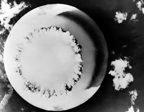 انفجار هسته ای در طول عملیات ایالات متحده چهارراه بر روی آیت الله بیکینی در اقیانوس آرام، 1946. این قاب از یک هواپیمای بدون سرنشین که بر فراز مرکز انفجار در حال پرواز بود در25 جولای 1946، بیکینی آتول، جزایر مارشال گرفته شده است. نمایی از بالای ابر  بزرگ ایجاد شده توسط انفجار بیکر، دومین مورد از سری آزمایش های  تسلیحات هسته ای جوی عملیات چهارراه در بیکینی آتول. بیکر در 90 فوت زیر آب در 25 جولای 1946 منفجر شد. - اسپوتنیک افغانستان  