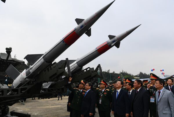 نخست وزیر ویتنام فام مین چین و مقامات به یک سیستم موشکی در طول نمایشگاه بین المللی دفاع ویتنام 2022 در هانوی. - اسپوتنیک افغانستان  
