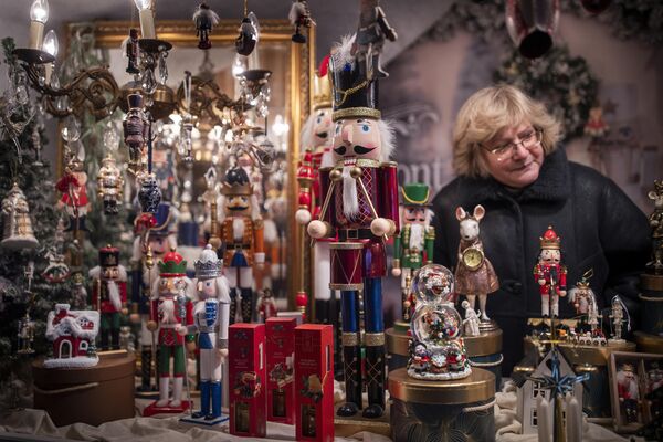 خانمی در بازار کریسمس در میدان &quot;کلیسای جامع&quot; در ویلنیوس، لیتوانی اسباب بازی می فروشد. - اسپوتنیک افغانستان  