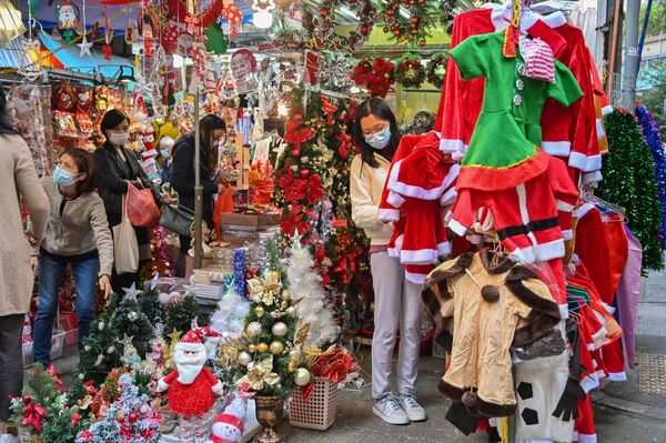 مردم در حین خرید لوازم کریسمس در یک بازار در هنگ کنگ هستند. - اسپوتنیک افغانستان  