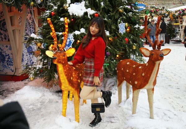 دختری  با تزیینات بازار کریسمس در مرکز تجاری گوم در&quot; میدان سرخ&quot;، مسکو عکس می گیرد. - اسپوتنیک افغانستان  