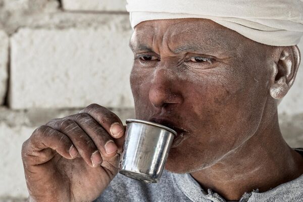 یک کارگر  روز 7 دسامبر 2019 در محل معدن سنگ آهک &quot;کوه سفید&quot; در نزدیکی شهر جنوبی مصر، منیا، در 265 کیلومتری جنوب پایتخت چای می نوشد. - اسپوتنیک افغانستان  