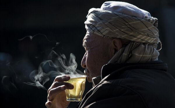 یک مرد افغان در 11 جنوری 2014 یک گیلاس چای را در مغازه لوازم یدکی وسایل نقلیه کهنه در کابل می نوشد. با فرا رسیدن زمستان در سراسر آسیای مرکزی، بسیاری از افغان ها برای تهیه غذا و سرپناه کافی برای خانواده های خود تلاش می کنند. - اسپوتنیک افغانستان  