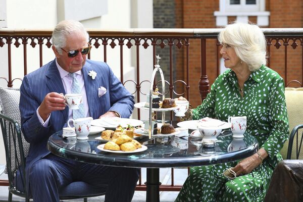 شاهزاده چارلز بریتانیا و کامیلا، دوشس کورنوال، در طی بازدید از تئاتر رویال دروری لین، مرکز لندن، چهارشنبه 23 جون 2021، چای عصرانه را در تراس می نوشند. - اسپوتنیک افغانستان  