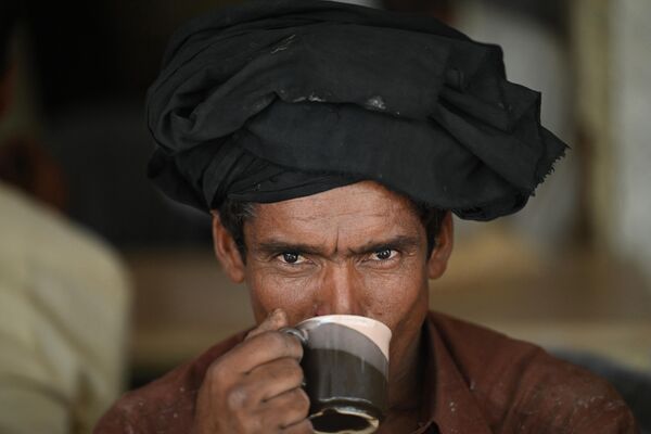 مردان در 15 جون 2022 در یک رستوران کنار جاده ای در اسلام آباد یک فنجان چای می نوشند. - یک وزیر پاکستانی با درخواست از شهروندان برای کاهش مصرف نوشیدنی &quot;چای&quot; به عنوان راهی برای حفظ ارز خارجی، طوفانی در گیلاس چای ایجاد کرده است. برگ های مورد استفاده در دم کردن نوشیدنی محبوب را وارد کنید. - اسپوتنیک افغانستان  