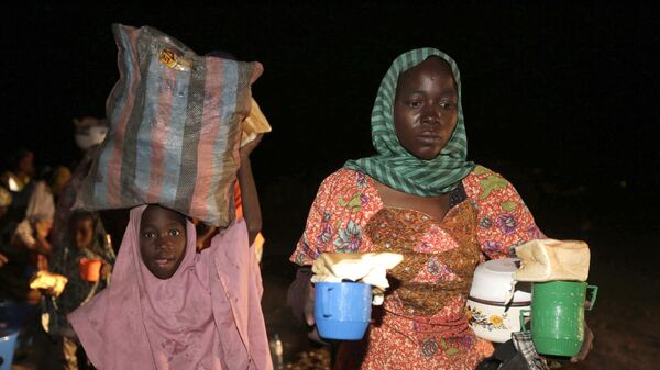Женщина и ребенок, спасенные нигерийскими солдатами от экстремистов Боко Харам в лесу Самбиса, несут чай и хлеб после прибытия вместе с другими в лагерь беженцев в Йоле, Нигерия - اسپوتنیک افغانستان  