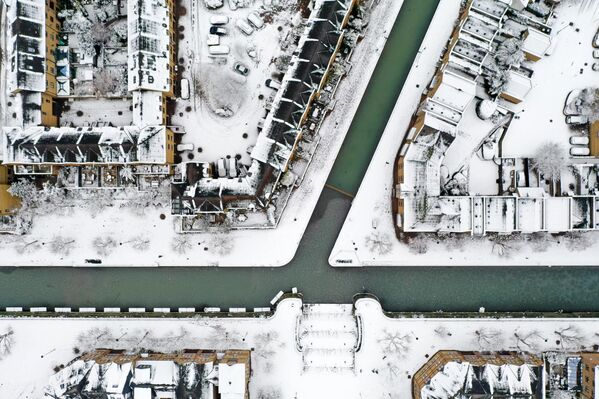 نمای هوایی از پشت بام خانه ها و جاده ها را پوشانده و کانالی در واپینگ در شرق لندن که پوشیده از برف است12 دسامبر 2022 - اسپوتنیک افغانستان  