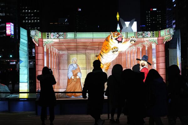 بازدیدکنندگان در طول جشنواره فانوس در میدان گوانگوامون در سئول، کوریای جنوبی، فانوس های روشن را مشاهده می کنند. این جشنواره از 19 دسامبر تا 31 دسامبر ادامه خواهد داشت. - اسپوتنیک افغانستان  