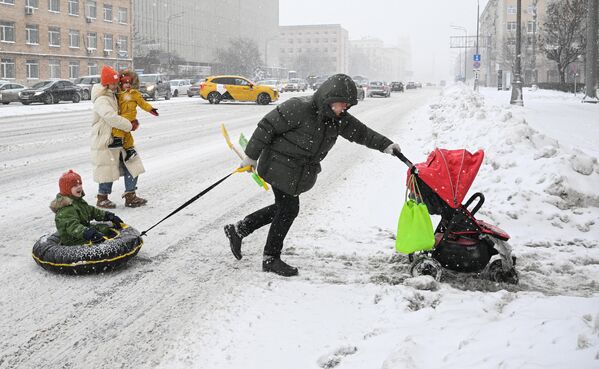 گذشتن سرک پر از برف یک مرد با فامیل اش در مسکو.  - اسپوتنیک افغانستان  