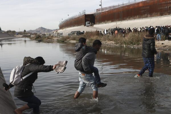 مهاجران از ریو گراند به سمت سرحد ایالات متحده و مکزیک در سیوداد خوارز، مکزیک عبور می کنند. - اسپوتنیک افغانستان  