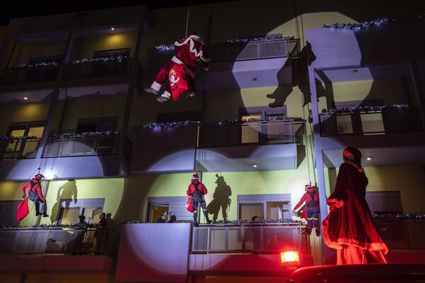 مأمور اطفائیه لباس بابانوئل پوشیده و به طناب آویزان شده‌اند در حالی که بیمارستان اصلی کودکان آتن را پایین می‌آورند تا هدایای کریسمس را به بیماران سرطانی خردسال که تعطیلات را در بیمارستان در آتن می‌گذرانند، تحویل دهند.پنجشنبه، 22 دسامبر 2022(عکس از/Petros Giannakouris) - اسپوتنیک افغانستان  