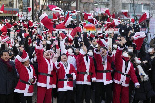 هان داک سو، نخست وزیر کره جنوبی، چهارمین نفر از سمت راست، و داوطلبانی که لباس های بابانوئل پوشیده اند، در طی یک مراسم خیریه کریسمس، قبل از تحویل هدایایی برای محرومان در سئول، کره جنوبی، کلاه های خود را به هوا پرتاب می کنند.شنبه، 24 دسامبر 2022 - اسپوتنیک افغانستان  