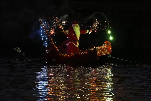 مردی که لباس بابا نوئل را به تن دارد، در حالی که روی قایق در ایمپریا، نزدیک جنوا، ایتالیا ایستاده، آتش بازی می کند.شنبه، 24 دسامبر 2022 - اسپوتنیک افغانستان  