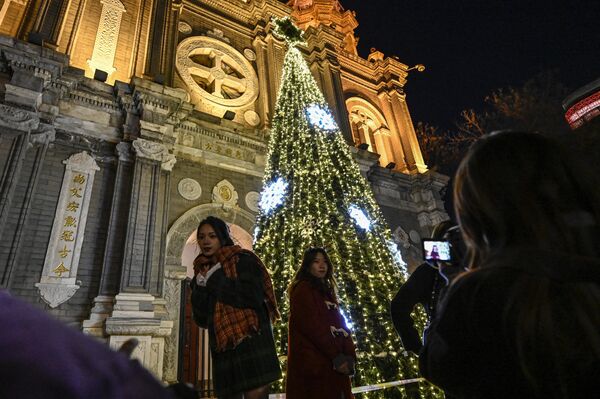 مردم در شب کریسمس در پکن مقابل کلیسای سنت جوزف عکس می گیرند.  24 دسامبر 2022 - اسپوتنیک افغانستان  