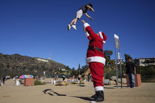 برایان مارتینز، اهل هالیوود شمالی، با لباس بابا نوئل، با پسرش، براکسون، 4 ساله، در پارک دریاچه هالیوود در لس آنجلس بازی می کند.شنبه، 24 دسامبر 2022 - اسپوتنیک افغانستان  