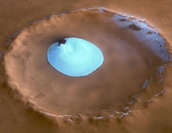 آژانس فضایی اروپا (ESA)، مریخ اکسپرس این منظره از یک دهانه ناشی از برخورد بدون نام واقع در Vastitas Borealis، دشت وسیعی که بیشتر عرض‌های شمالی دور مریخ را پوشش می‌دهد، به دست آورد. تکه دایره ای از مواد روشن که در مرکز دهانه قرار دارد، یخ آب باقیمانده است. رنگ ها بسیار نزدیک به طبیعی هستند، اما برجستگی عمودی توپوگرافی سه بار اغراق شده است. این تکه یخ در تمام طول سال وجود دارد و پس از پوشاندن دی اکسید کربن منجمد روی آن در تابستان مریخ ناپدید می شود. - اسپوتنیک افغانستان  
