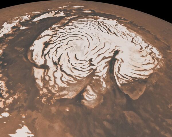 این تصویر، ترکیبی از داده‌های دو ابزار Mars Global Surveyor ناسا، نمایی مداری از ناحیه قطب شمال مریخ را نشان می‌دهد. کلاهک قطبی پراز یخ (ناحیه سفید شبه دایره‌ای در مرکز) تقریباً 1000 کیلومتر (621 مایل) است.  - اسپوتنیک افغانستان  